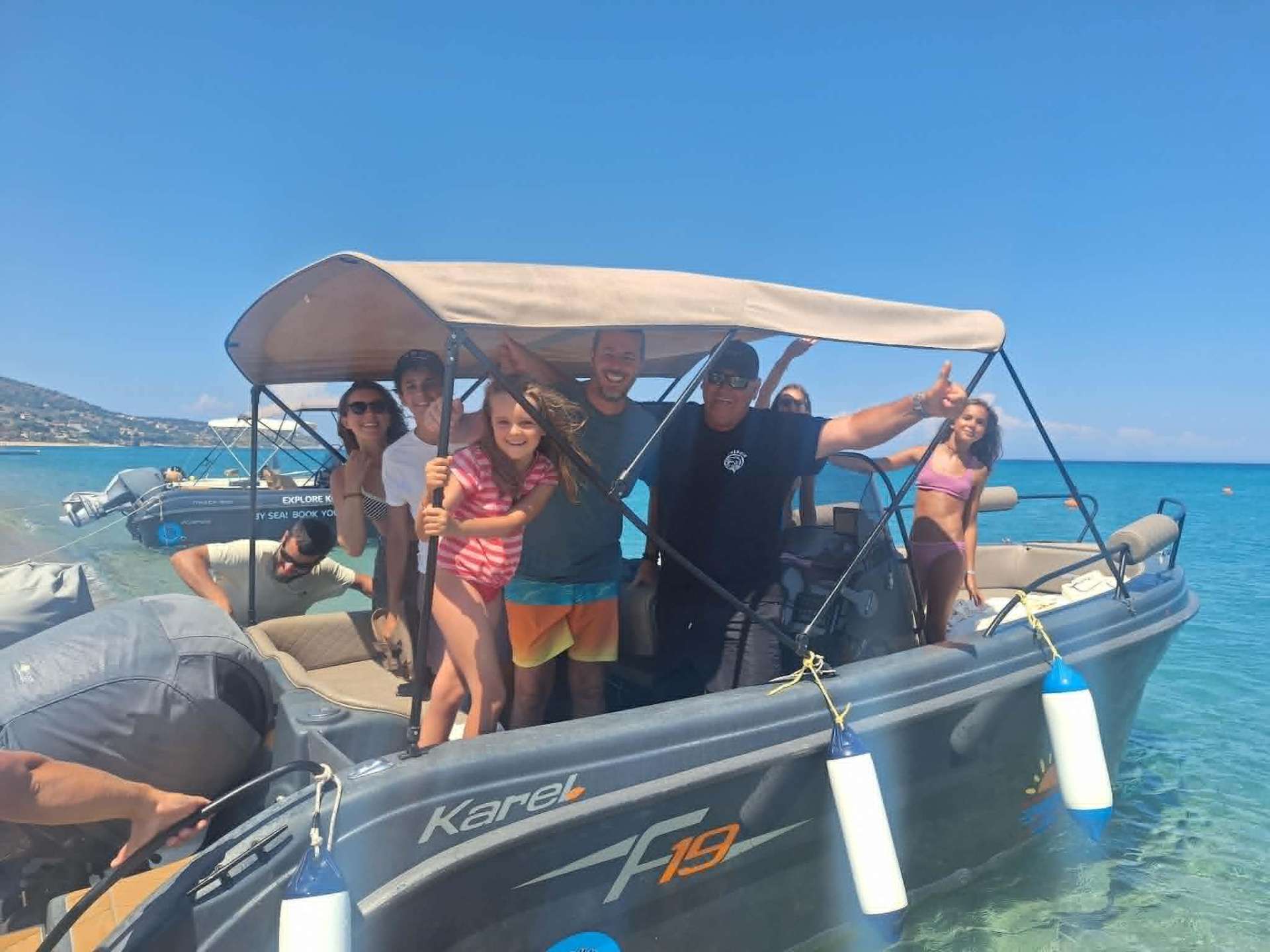 Family waving from a Dolphin Ski Club boat